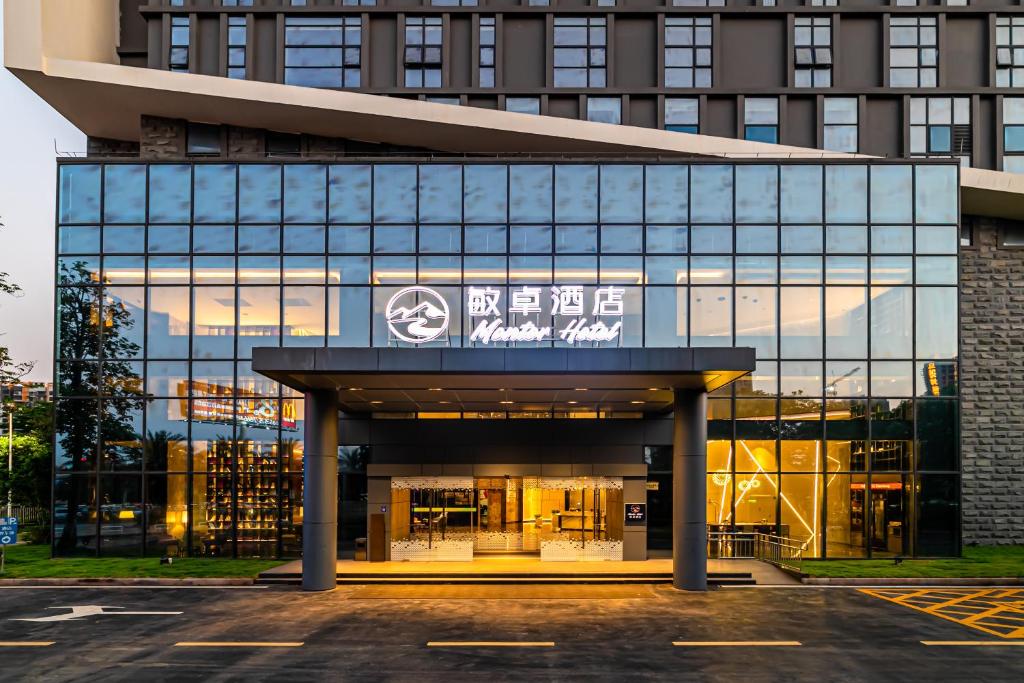 un edificio con un cartel en la parte delantera en 敏卓酒店Mentor Hotel en Foshan