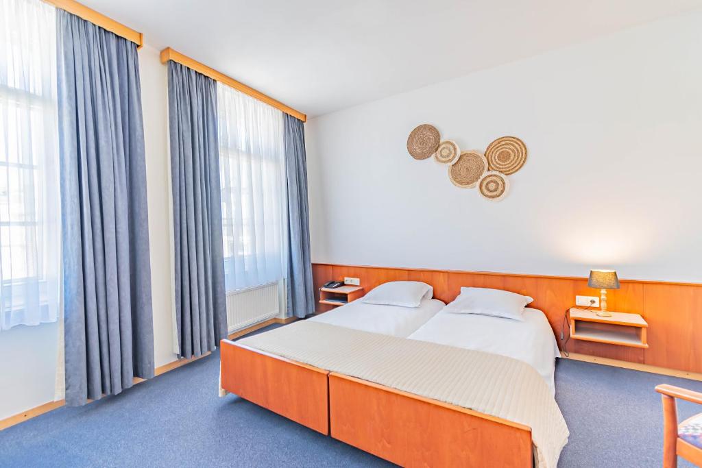 Postel nebo postele na pokoji v ubytování Hôtel Le Petit Poète