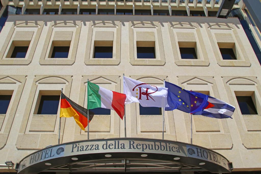 a building with different flags on the front of it at HR Hotel in Monfalcone