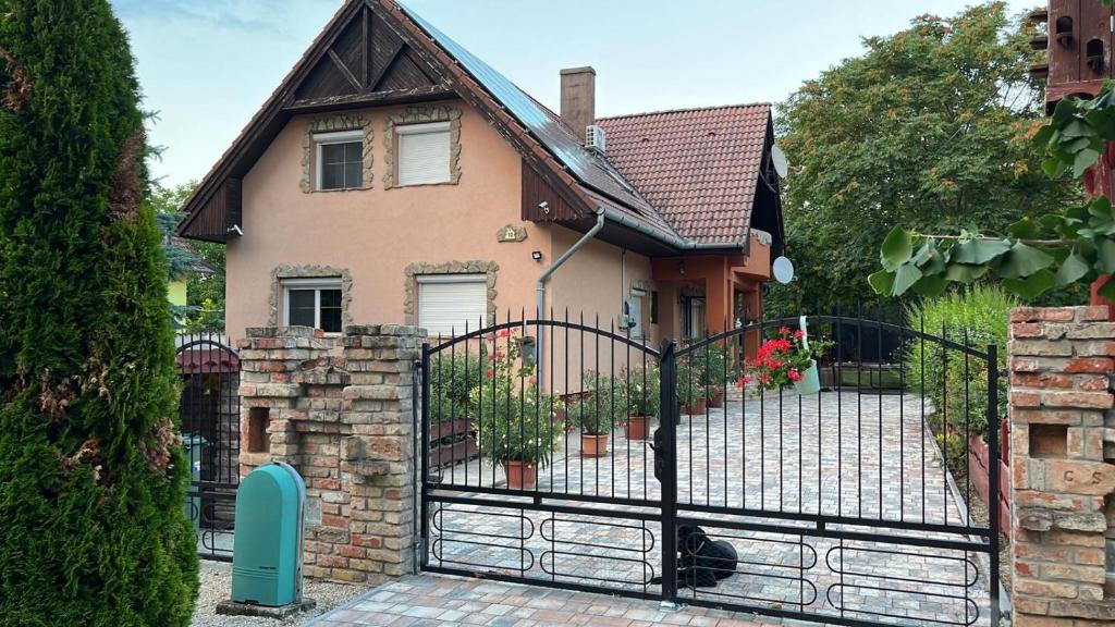 ein Haus mit einem Tor davor in der Unterkunft Bonita Apartman in Balatonberény