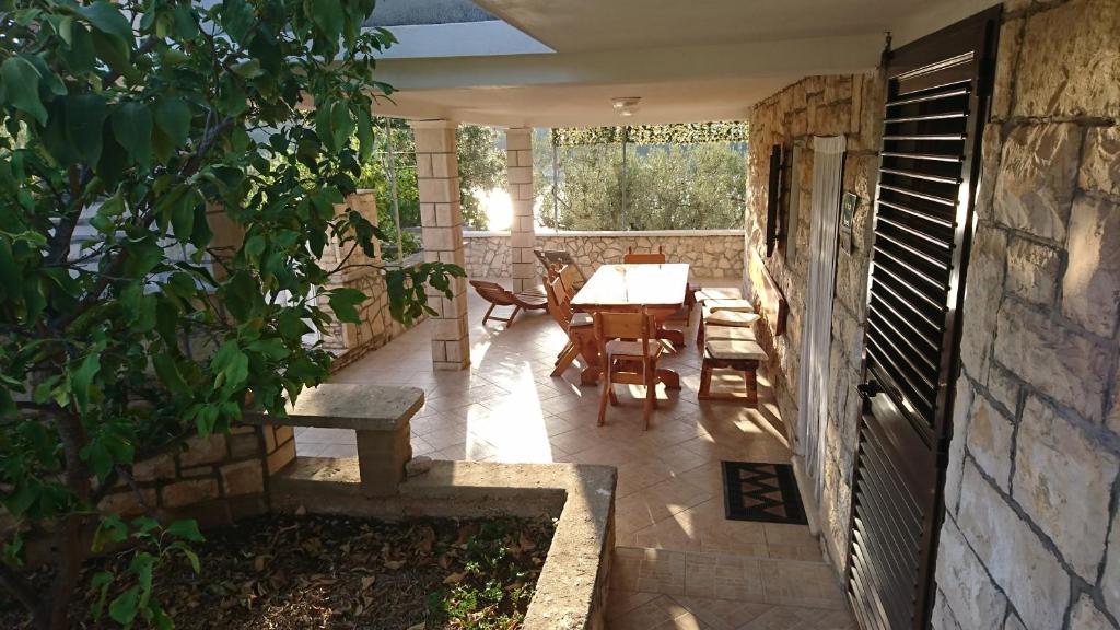 d'une terrasse avec une table, des chaises et une fenêtre. dans l'établissement Ugodna atmosfera privatnosti, more u blizini., à Vela Luka