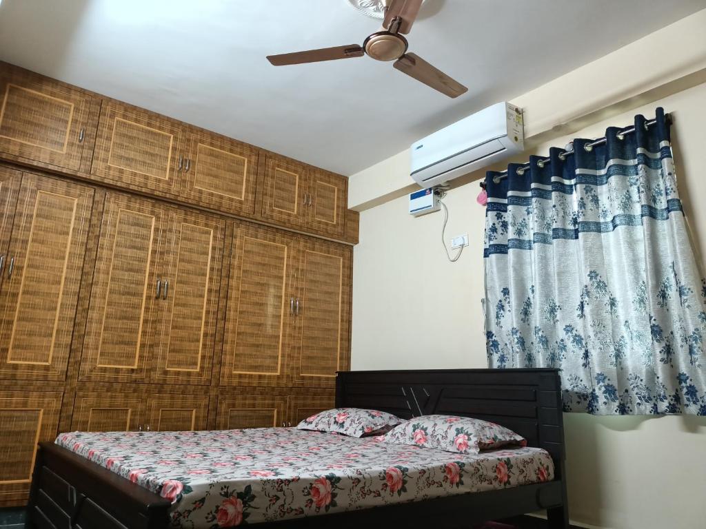ADVIK HOMESTAYS في تيروباتي: غرفة نوم بسرير ومروحة سقف