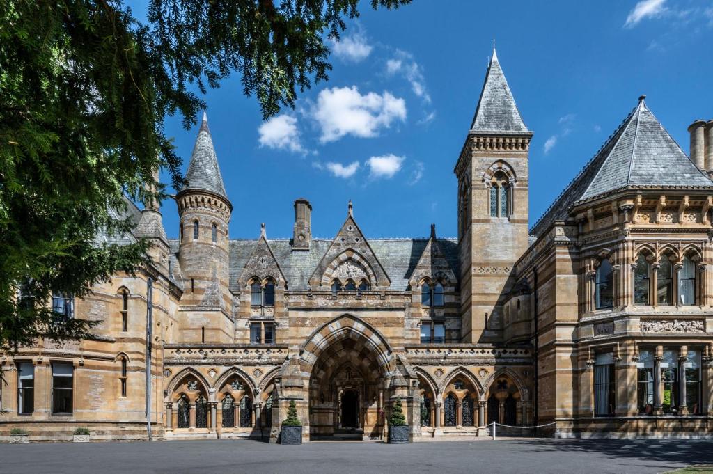 een groot stenen gebouw met een toren bij Ettington Park Hotel, Stratford-upon-Avon in Stratford-upon-Avon