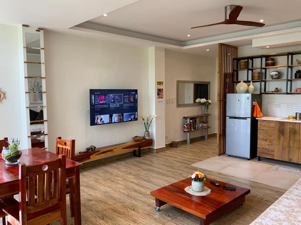 a living room with a table and a refrigerator at Puntakana Apartelle Spacious Apartment Panglao in Panglao