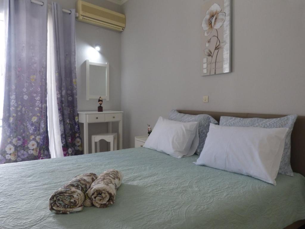 a bedroom with a bed with two towels on it at Golden Keys Apartment ground floor in Moraitika