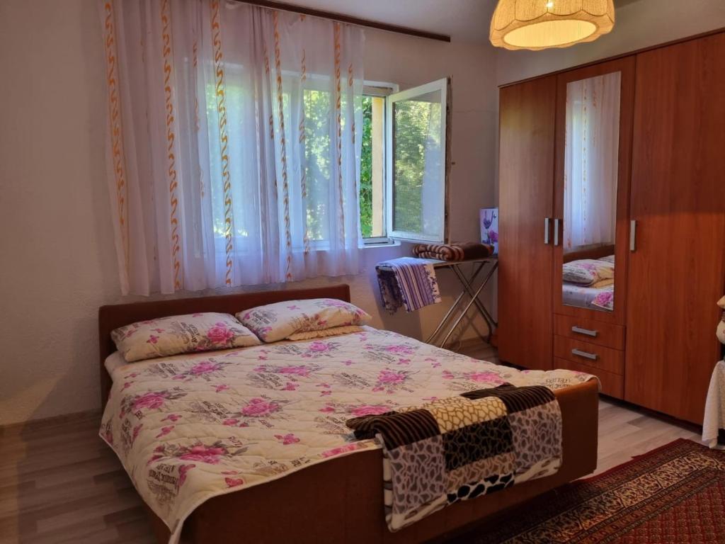 a bedroom with a bed and a dresser and windows at Apartment Nura in Bihać