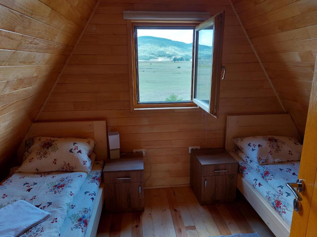 2 letti in una piccola camera con finestra di Vule bungalovi a Žabljak