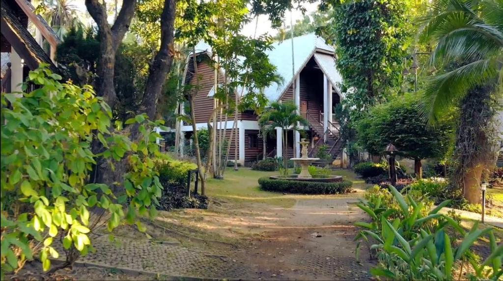 una casa con una palmera delante de ella en Royal Ping Garden and Resort, en Mae Taeng