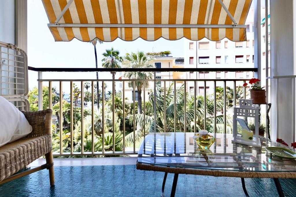 un salon avec une table en verre et un balcon dans l'établissement Sanremo Dream - Casa di Pietro, à Sanremo