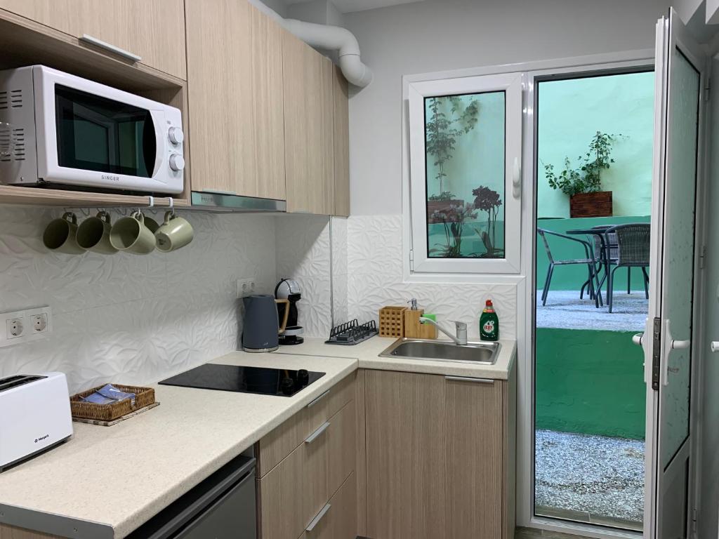 Kuchyň nebo kuchyňský kout v ubytování Cozy Apartment Metaxourgeio greendom