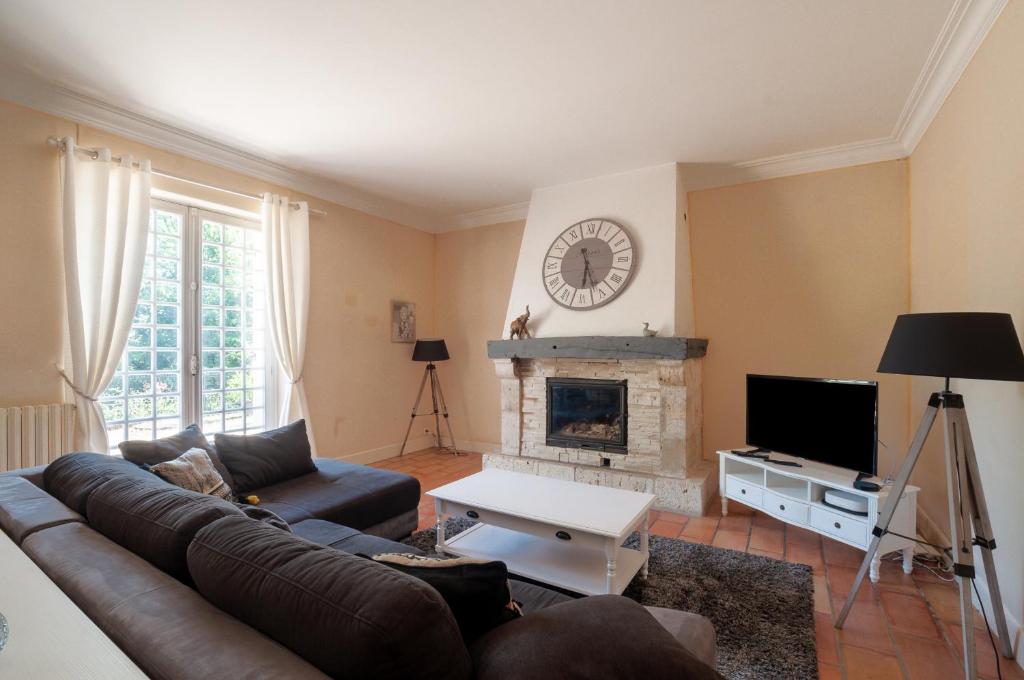 a living room with a couch and a fireplace at Au Bonheur Caché in Vianne