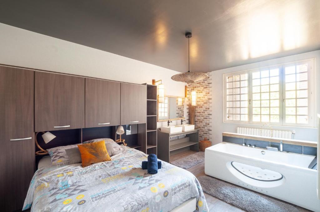 a bedroom with a bed and a tub and a sink at Au Bonheur Caché in Vianne