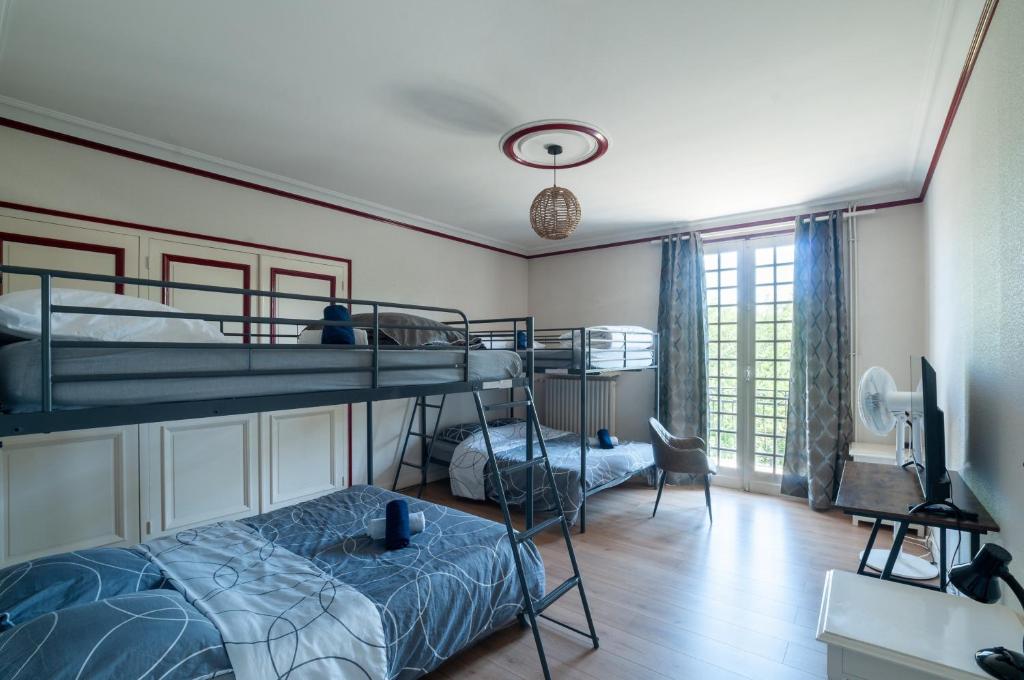 a bedroom with two bunk beds and a television at Au Bonheur Caché in Vianne