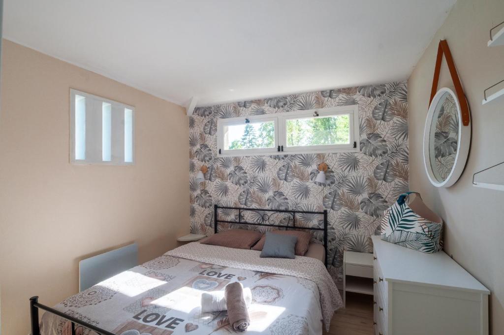 a small bedroom with a bed and a desk at Au Bonheur Caché in Vianne