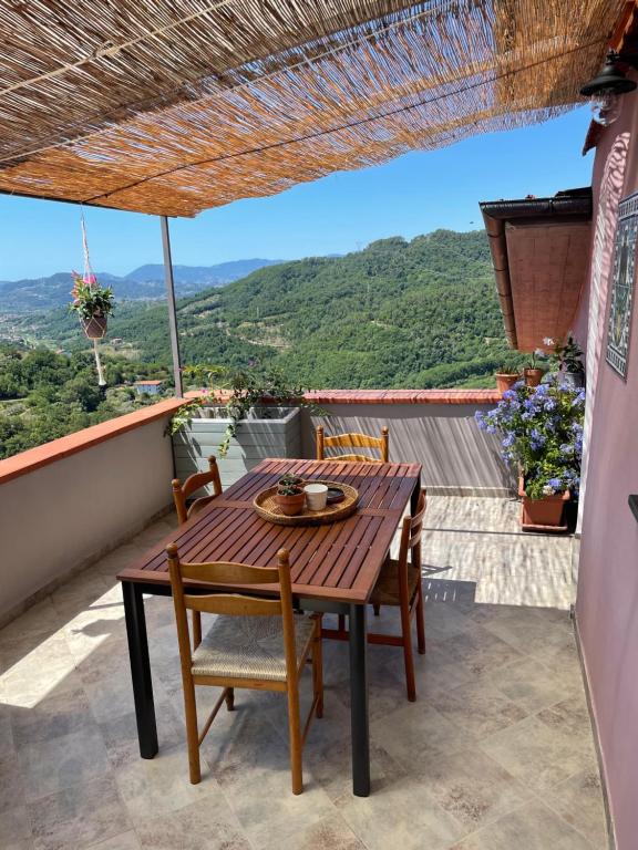 a wooden table and chairs on a balcony with a view at La Casa nel Borgo in Fosdinovo