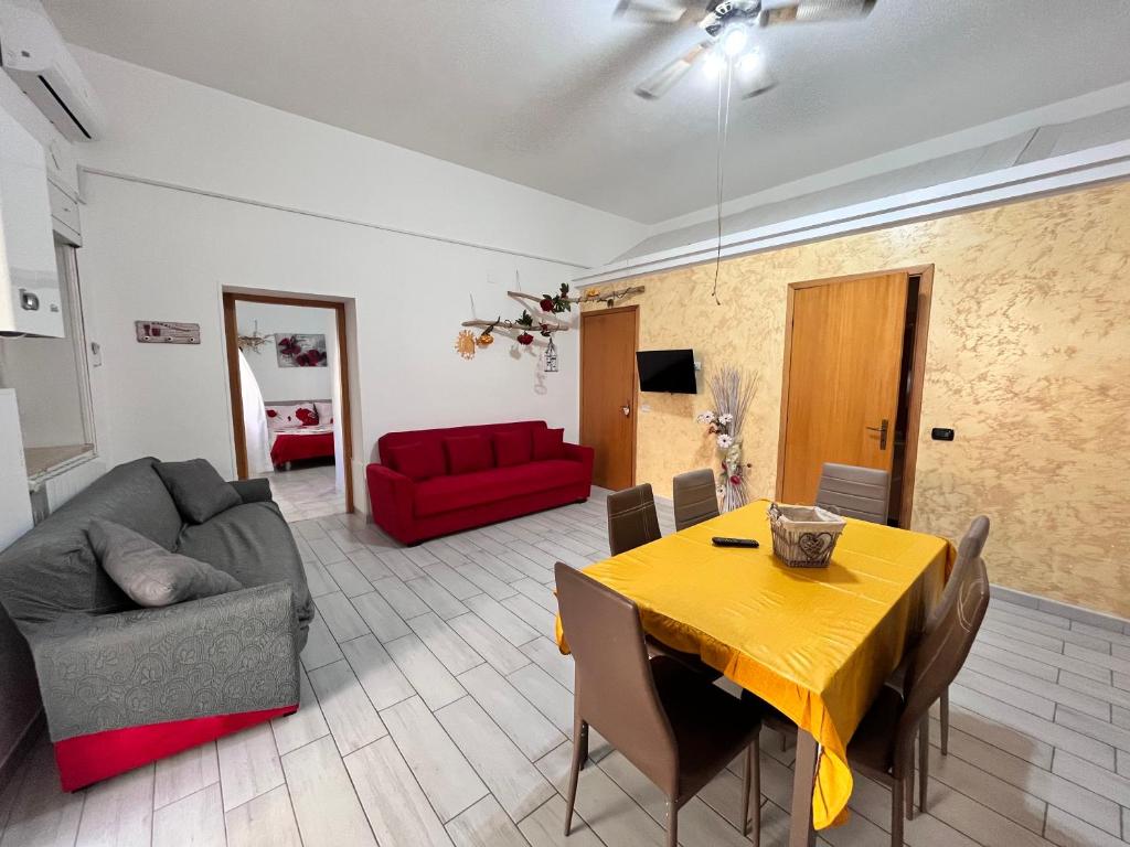 Montalbano JonicoにあるCasa Planetのリビングルーム(黄色のテーブル、赤いソファ付)