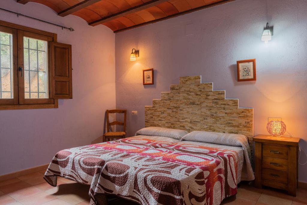 a bedroom with a bed and a brick wall at CASAS RURALES LA TOBICA in Yeste