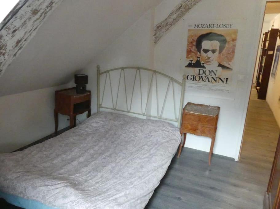 um quarto com uma cama e uma placa na parede em B2 Appartement entier centre ville tout confort em Courtenay