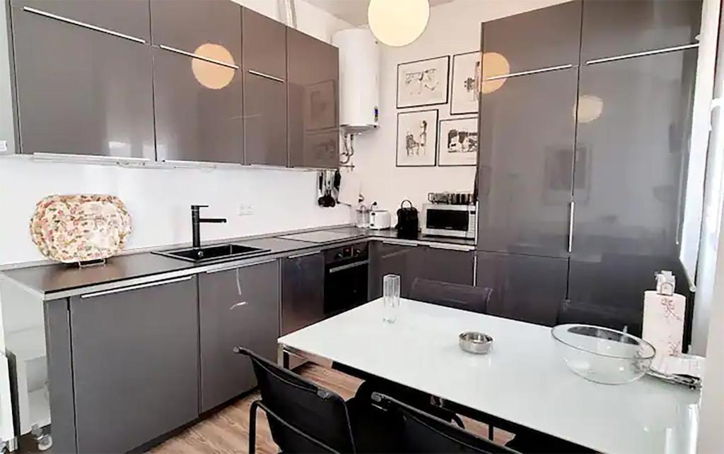 une cuisine avec des placards gris et un comptoir blanc dans l'établissement FLORIT FLATS - The Canovas Apartment, à Valence