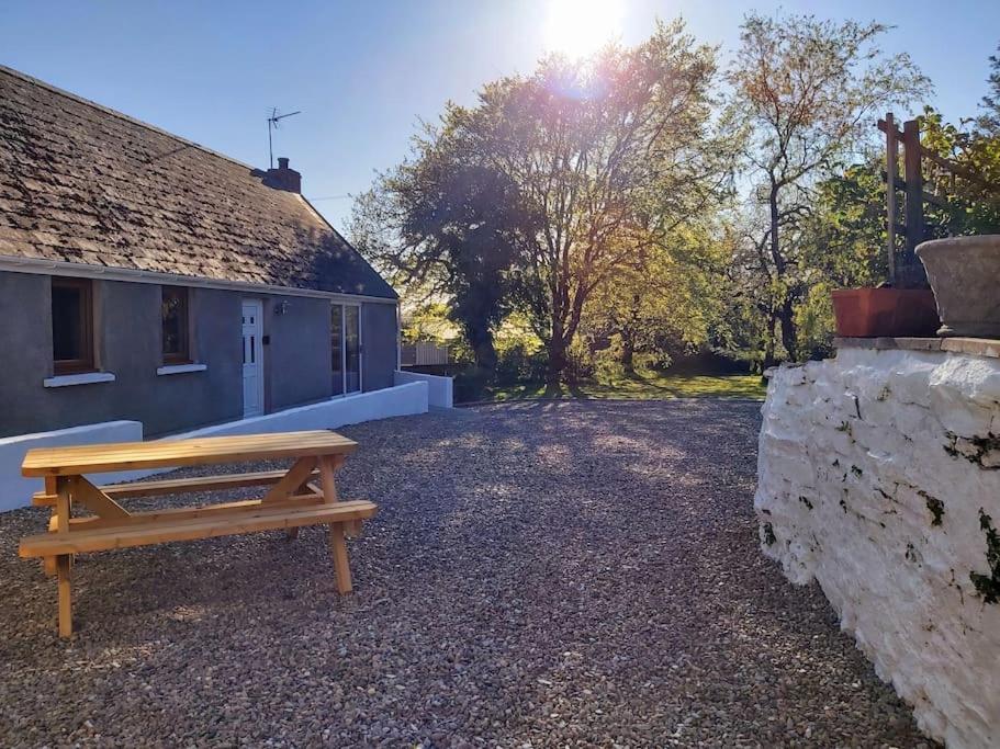 a wooden bench sitting outside of a house at Converted Stables at Peaceful Family Farm Stay in Pembrokeshire