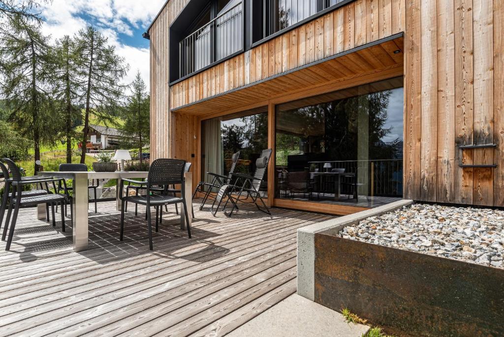 drewniany taras ze stołem i krzesłami w obiekcie Chalet Bergfreund w mieście Valdaora