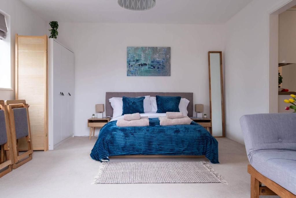 a bedroom with a large bed with blue pillows at Little Nye in Milford on Sea