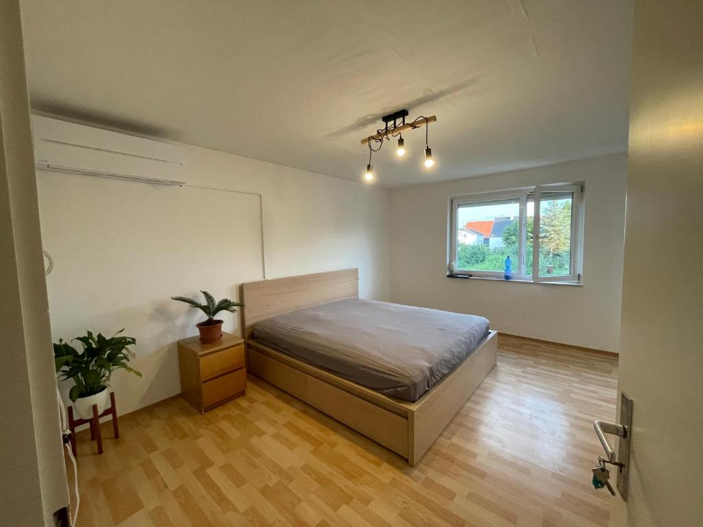 1 dormitorio con cama y ventana en Sonnige 3 Zimmer Wohnung mit schönem Balkon im Grünen, en Reutlingen