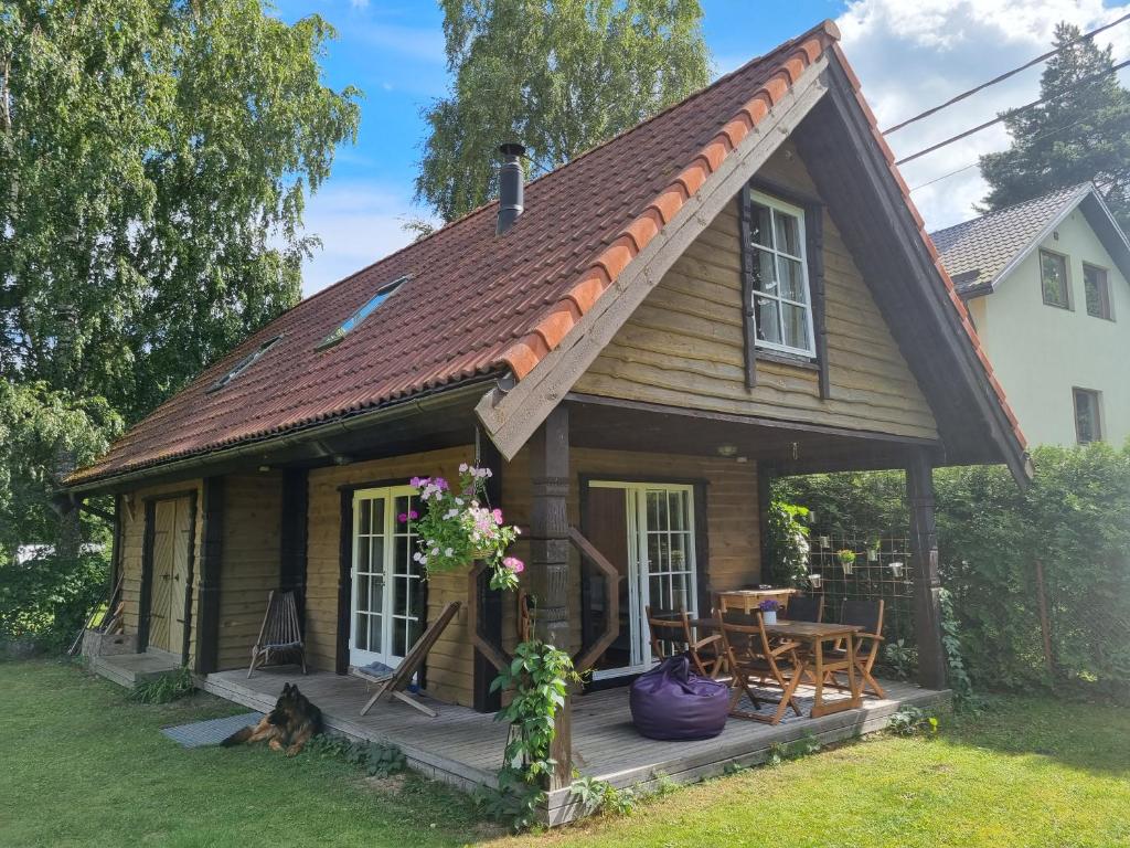 uma pequena casa com um alpendre e uma mesa em Norwegian saunahouse em Haapse