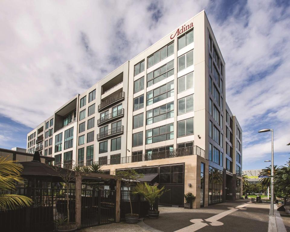 un edificio blanco con un cartel en el costado en Adina Apartment Hotel Auckland Britomart en Auckland