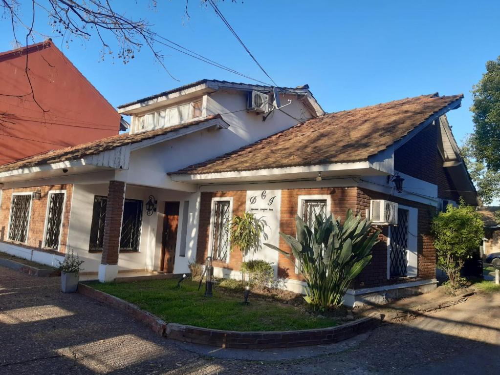 uma casa velha com um telhado vermelho em Hotel Duclout Confort Inn em Monte Grande