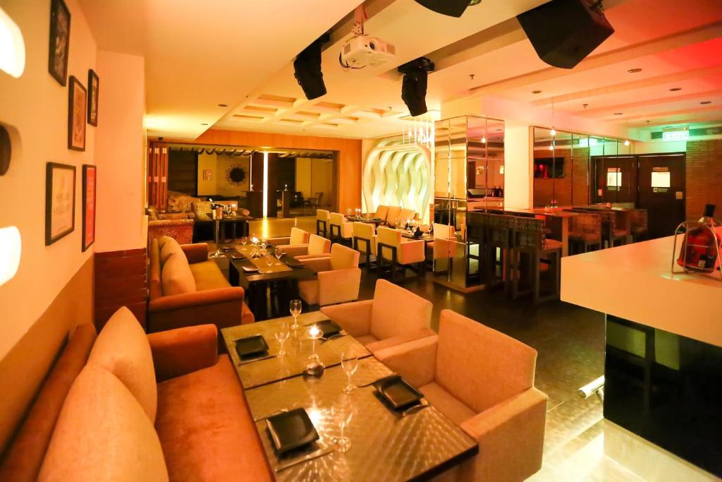 een restaurant met banken en tafels en een eetkamer bij Hotel Icon in Chandīgarh