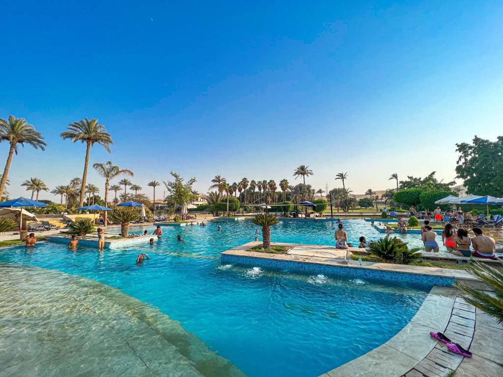 einen Pool in einem Resort mit Leuten darin in der Unterkunft Sakkara Country Club in Kairo