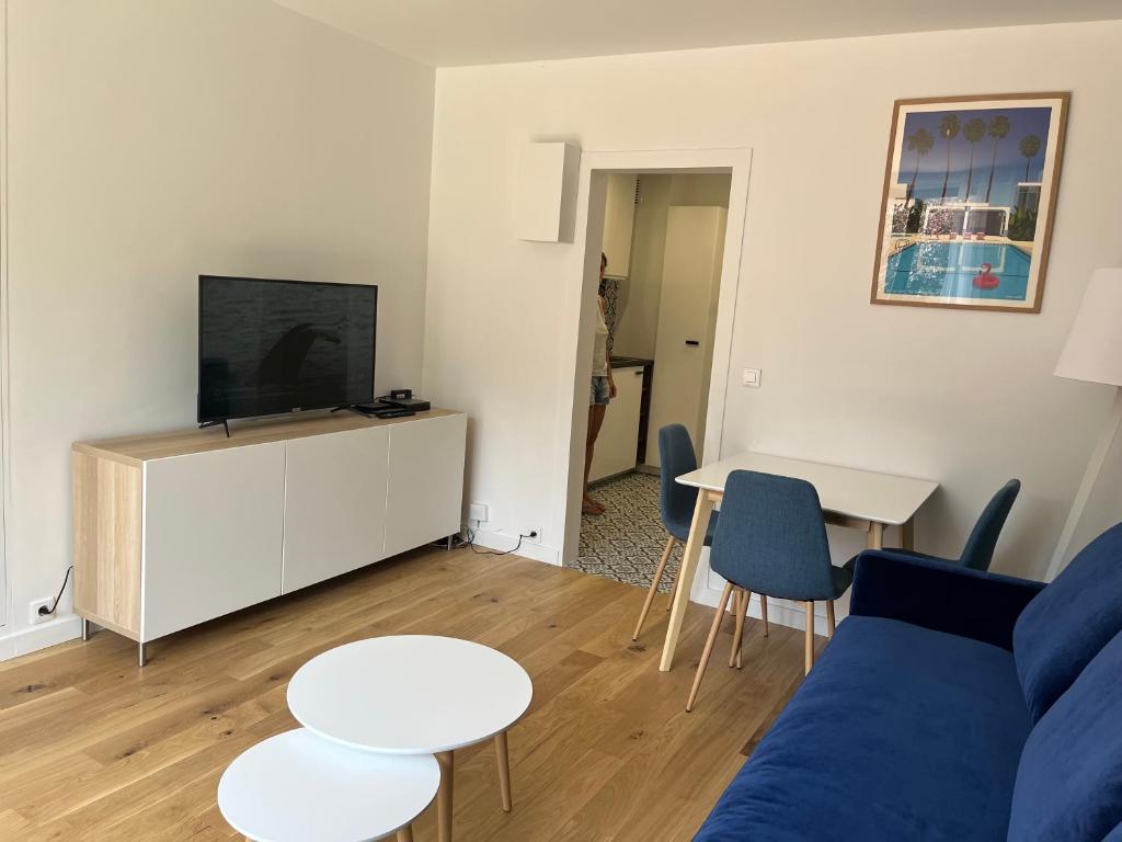 ein Wohnzimmer mit einem blauen Sofa und einem Tisch in der Unterkunft STUDIO PROCHE PARIS VERSAILLES in Villennes-sur-Seine