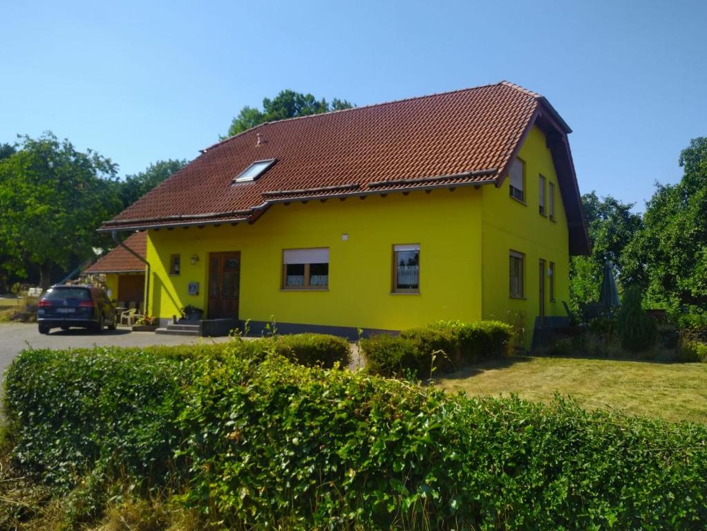 a yellow house with a red roof at Urlaub mit Hund auf dem Bauernhof Hofswald in Euscheid