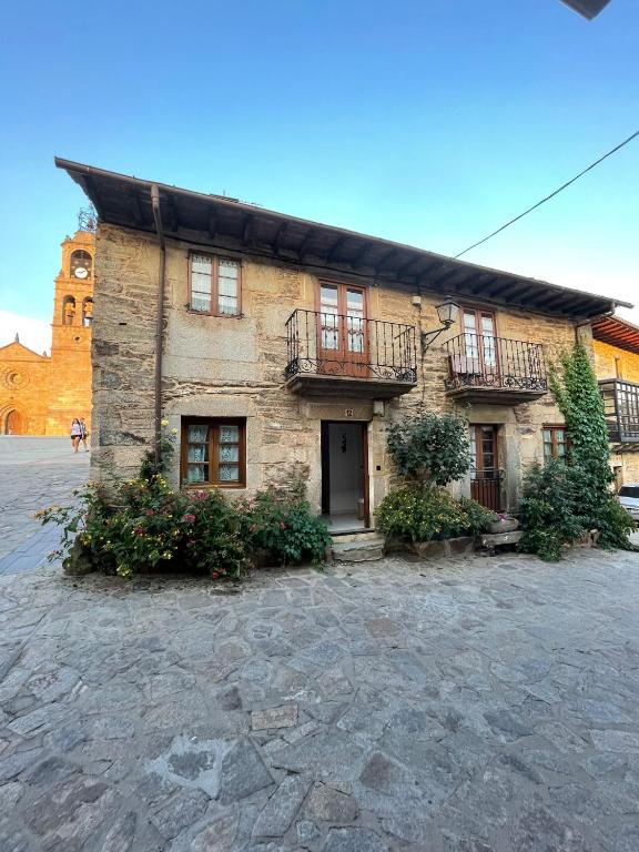 a brick building with windows and balconies on it at Casa Tía Milagros in Puebla de Sanabria