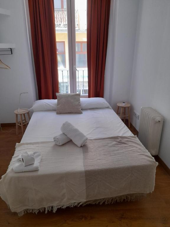 1 dormitorio con 1 cama grande y 2 toallas. en Espoz habitaciones, en Madrid