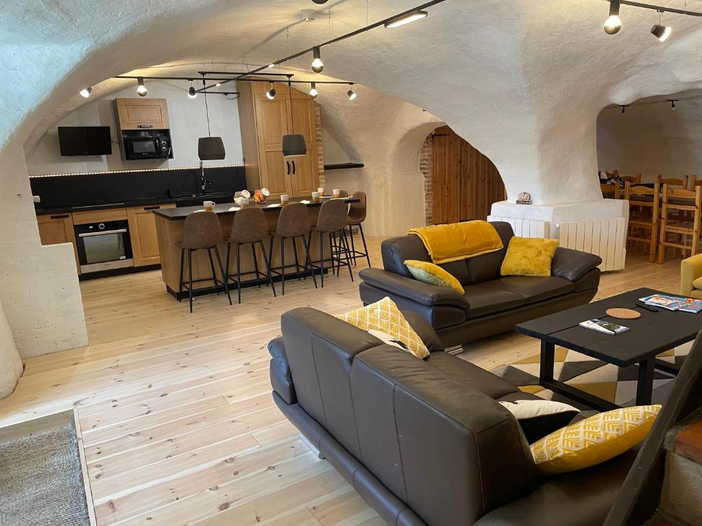 un salon avec des canapés et une table ainsi qu'une cuisine dans l'établissement Résidence - Gite La Mourée, à Vars