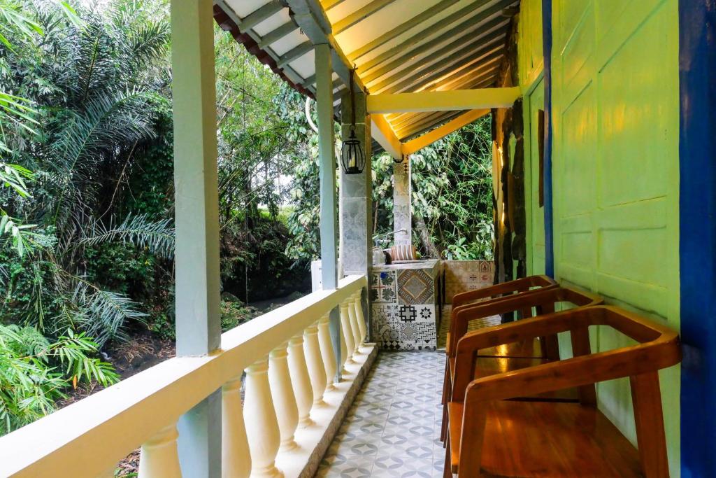 un porche de una casa con 2 sillas en Villa Kamar Tamu Selomartani 2, en Sleman