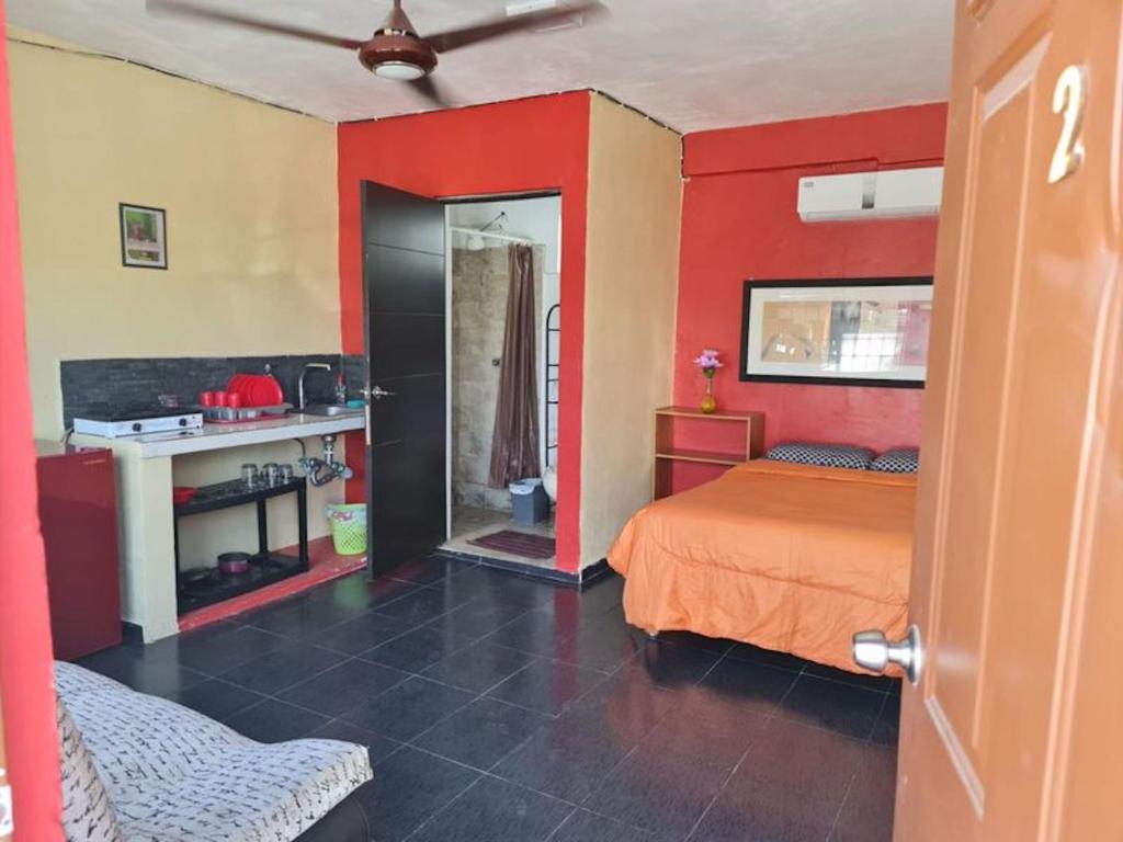 - une chambre avec des murs rouges et jaunes et un lit dans l'établissement Independent Apartment Wifi A C, Stove, Refrigerator, Tv, à Mérida