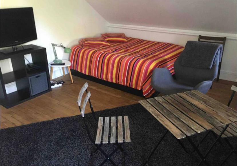 - une chambre avec un lit, une chaise et une table dans l'établissement Studio à Rambouillet, à Rambouillet