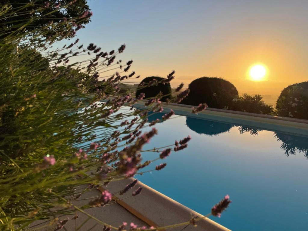 una piscina con puesta de sol en el fondo en Casa le Querce, en Castiglione del Lago