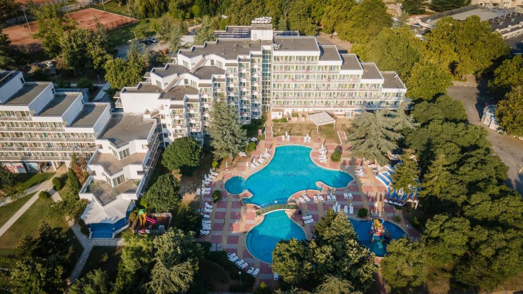 a large swimming pool surrounded by trees and palm trees at Hotel Laguna Garden in Albena