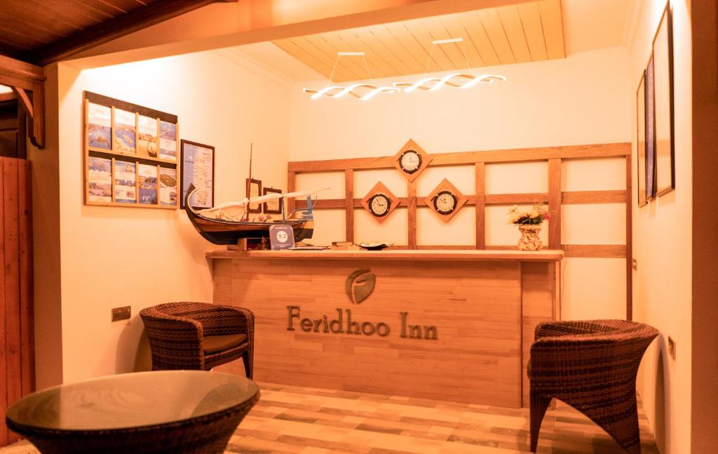 a restaurant with a bar with a table and chairs at Feridhoo Inn in Feridhoo
