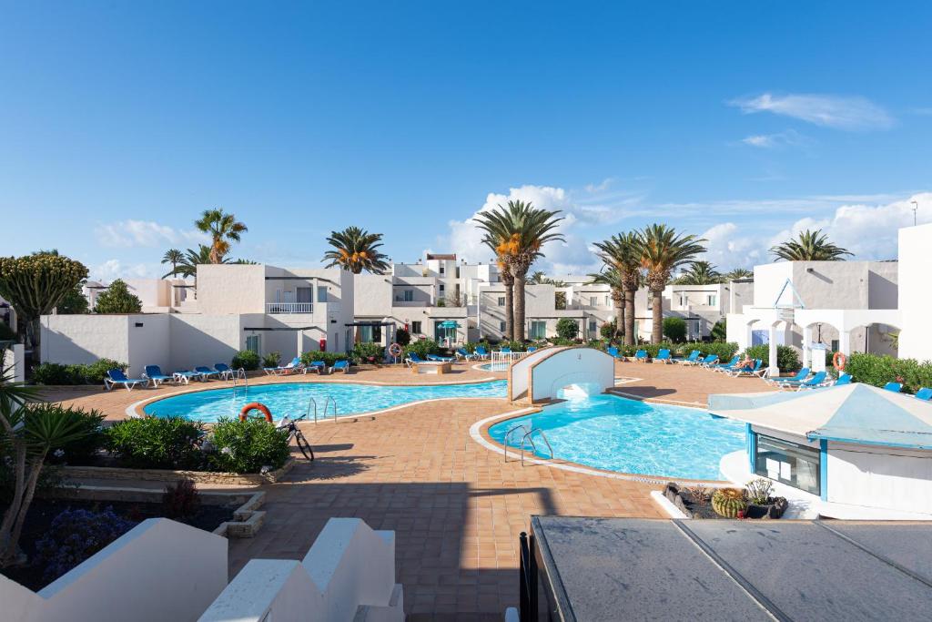 une image de la piscine d'un complexe dans l'établissement HomeForGuest Apartamento Alisios 1 con piscina en Corralejo, à Corralejo