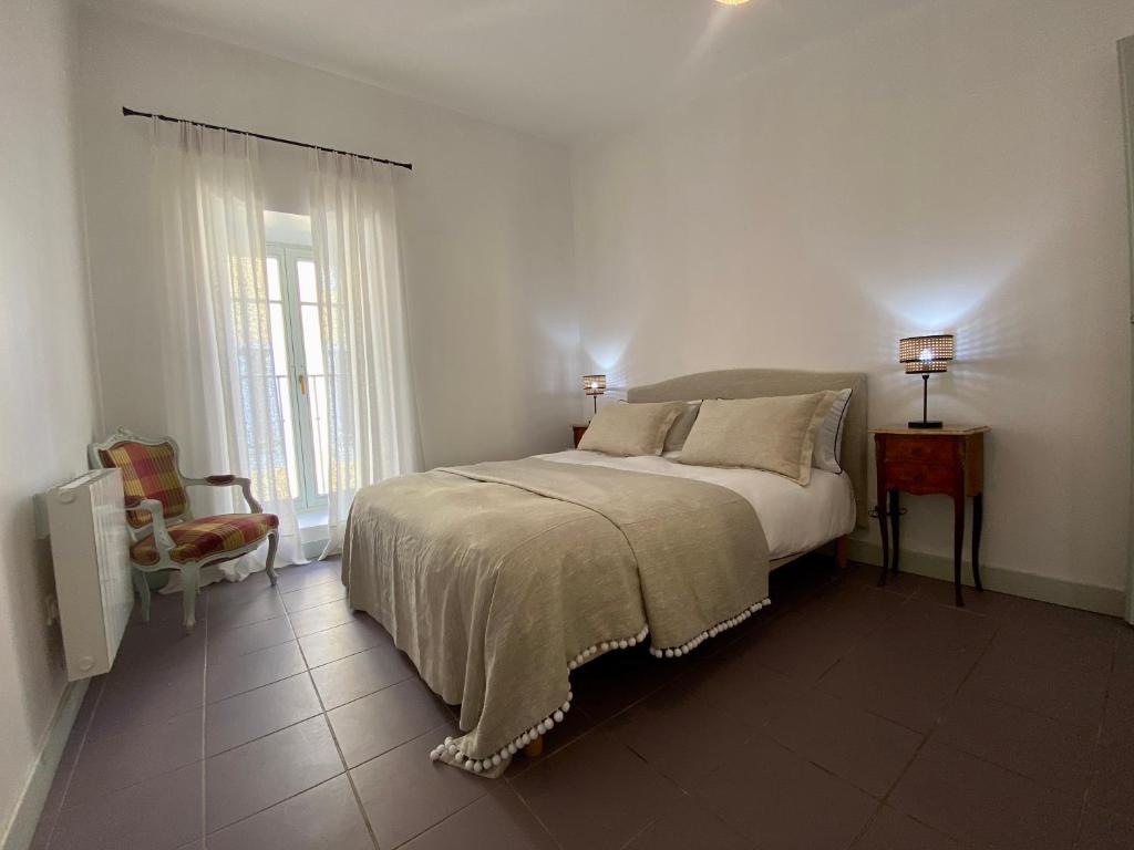 Un dormitorio con una cama, una silla y una ventana en Casa Poliglota - 100m de la Cité Médiévale, en Carcassonne