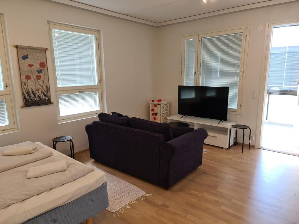 a living room with a couch and a flat screen tv at MR Apartments 2 in Vaasa