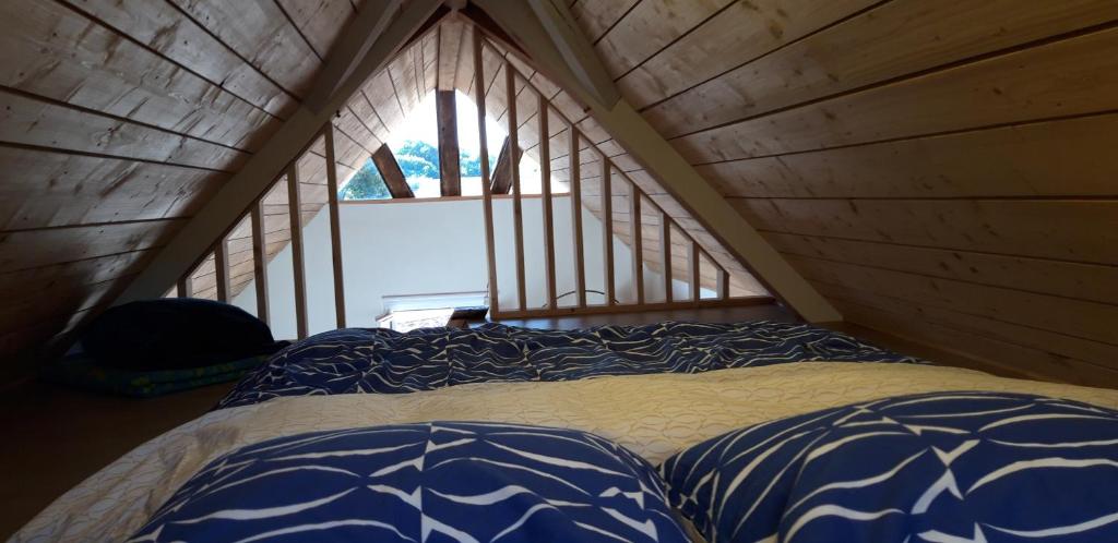 Gîte pour 2 في Wingen: سرير في غرفة خشبية مع نافذة