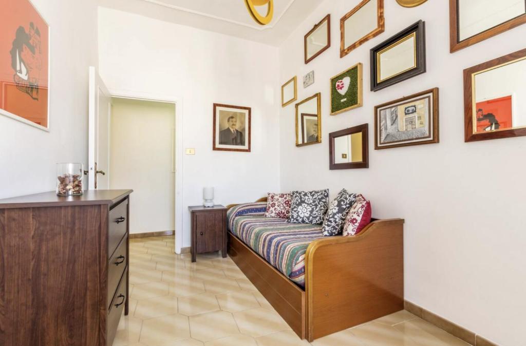 salon z kanapą i obrazami na ścianie w obiekcie Casa Rossi Roma w Rzymie