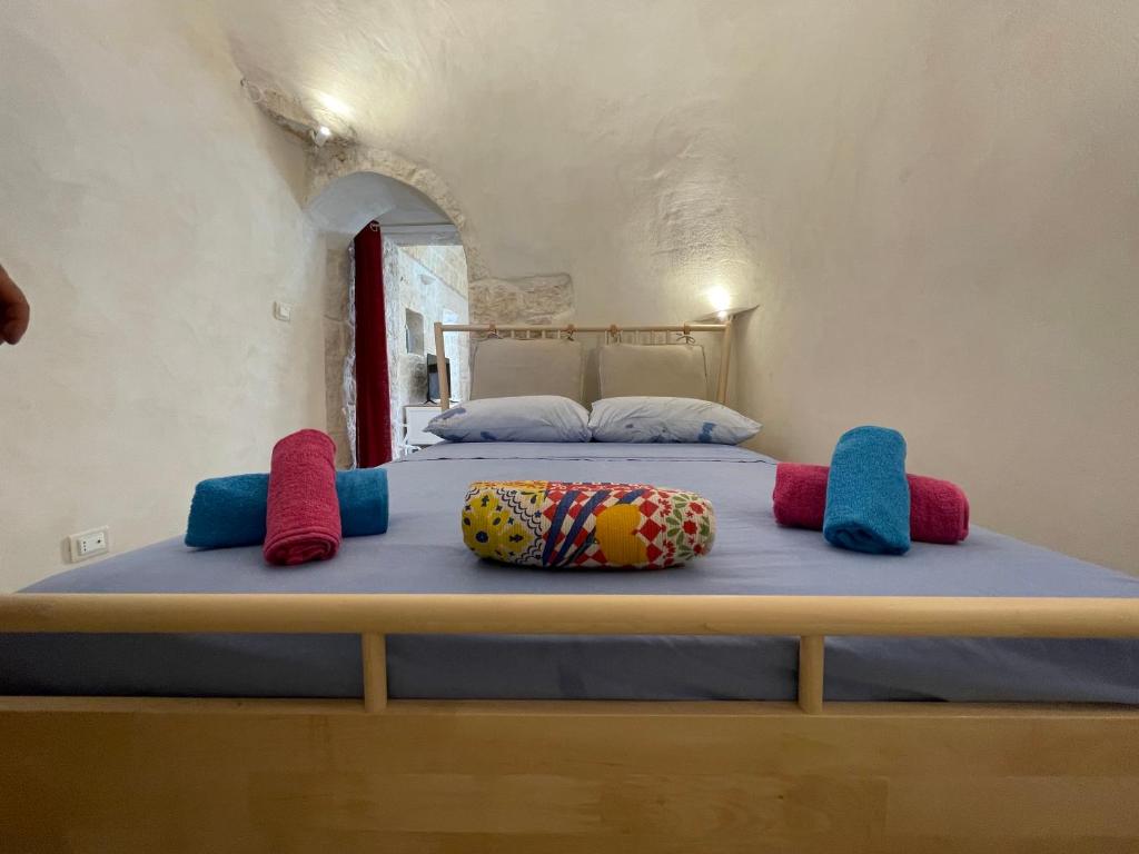 Bett mit vier Kissen auf einem Zimmer in der Unterkunft Trullo Bubamare in San Michele Salentino