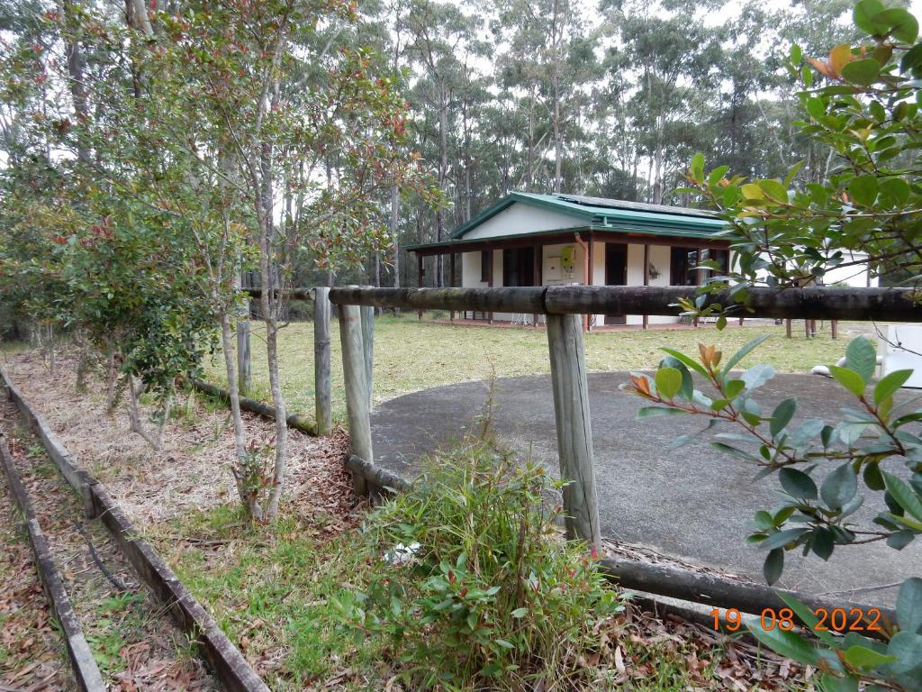 ein kleines Gebäude mit einem Zaun in einem Park in der Unterkunft Self-contained Cabin 10 min to Huskisson in Tomerong